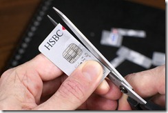 Durham, England - December 7, 2011: A Visa debit card provided by HSBC (Hong-Kong Shangai Bank of China) in England is being cut (destroyed) with scissors after its expiration date. Number and signature are not fully identifiable.