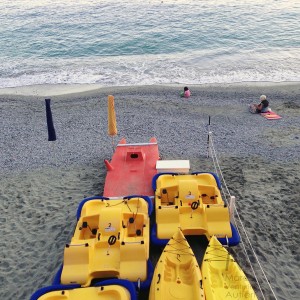 Evening, beach almost empty, rescue boats onshore.